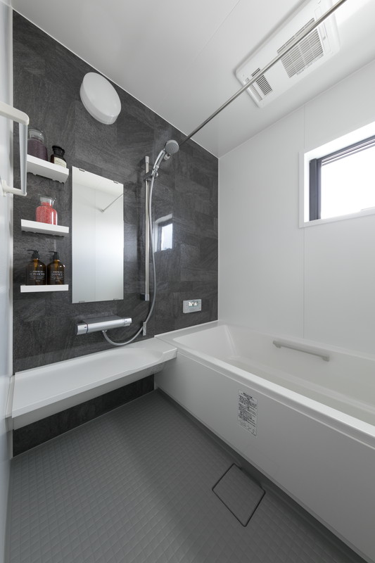 ヴィンテージスタイルにフルリノベーションした八王子エリアの戸建てバスルーム。ダークグレーの壁面パネルを採用。