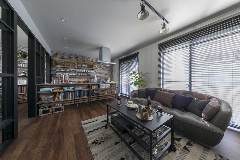 八王子市の中古戸建てリノベーション事例。レンガ調クロスとウッドワンのフレームキッチンがあるヴィンテージスタイルのリビング。