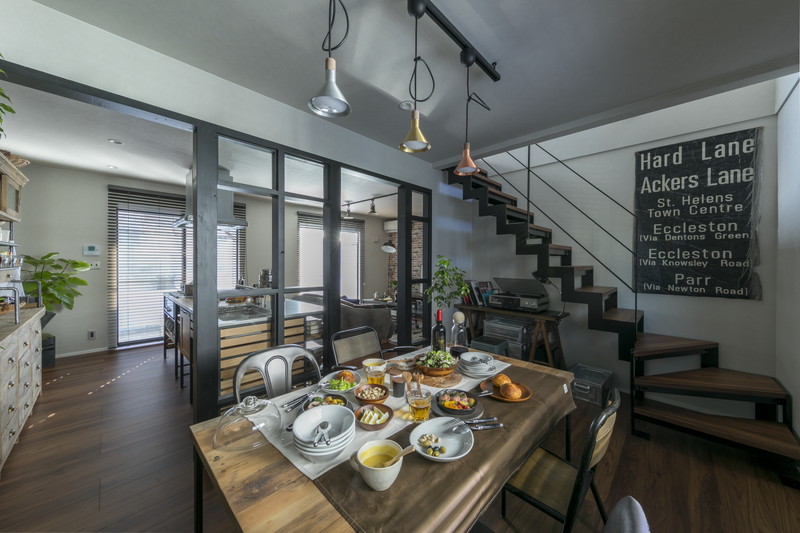 鉄骨のスケルトン階段とブラックフレームの間仕切りがあるダイニング。中古戸建てのフルリノベーション事例。
