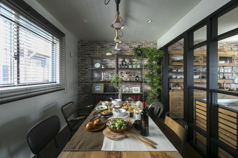 ヴィンテージスタイルのダイニングテーブルとレンガ調壁面のオープン収納。