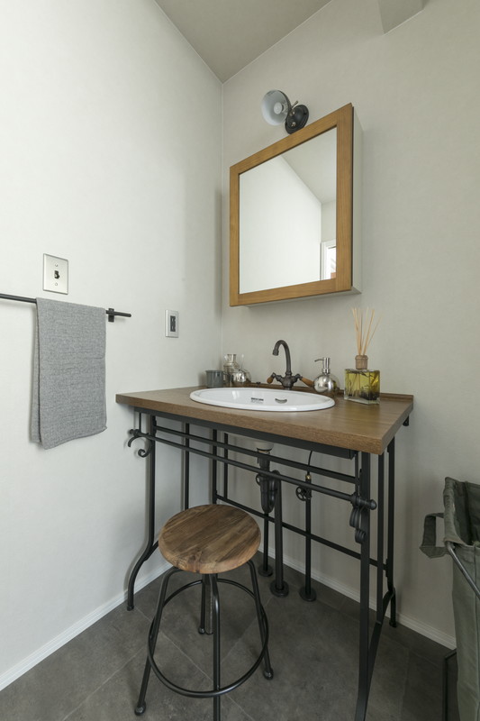 アイアンの脚と木製カウンターを組み合わせた造作洗面台。ヴィンテージテイストのサニタリールーム。