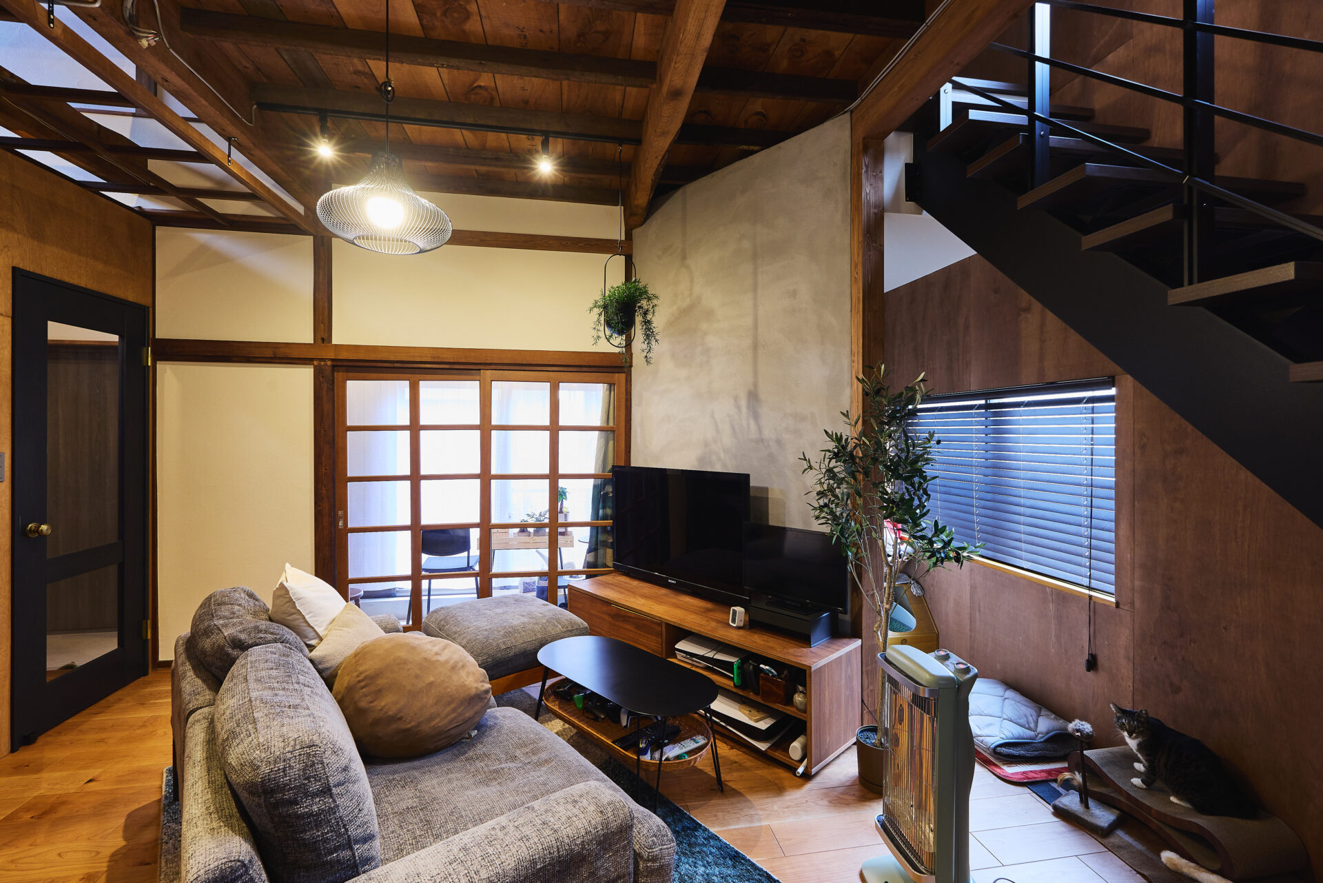 T様邸の工事後のリビング。ソファとテレビを配置し、既存の木製ガラス建具を残した空間